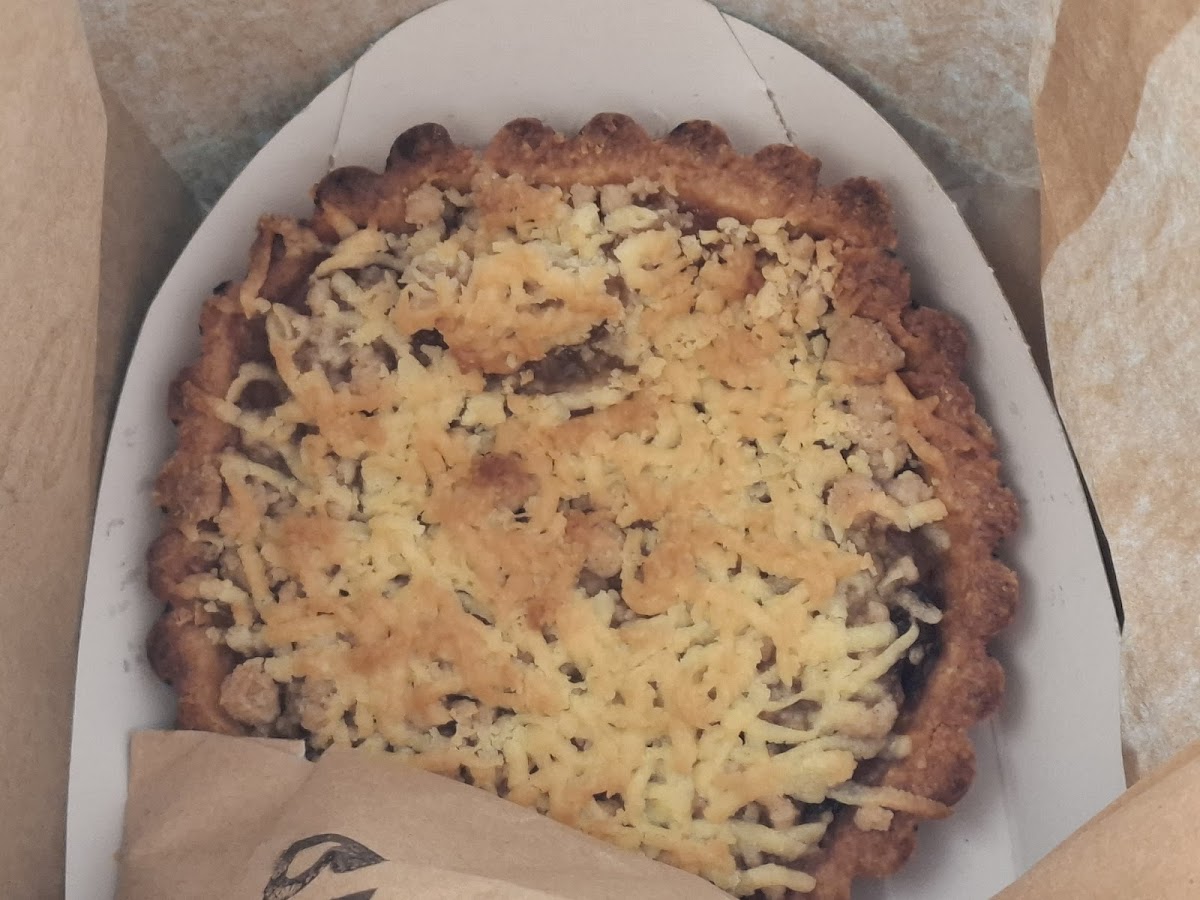 Golden cheesy savoury tart in a takeaway box from BROOD
